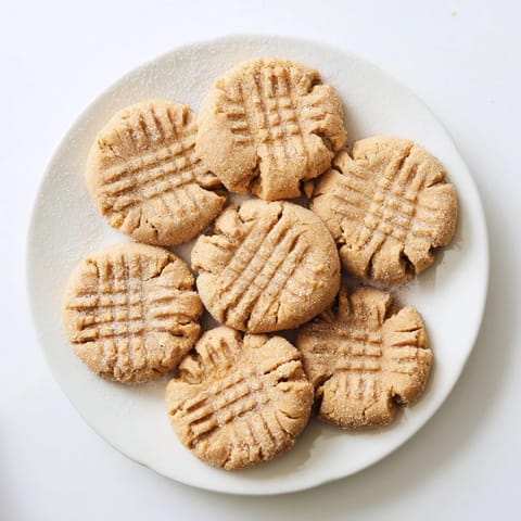 Warm, chewy Peanut Butter Cookies rolled in sugar, paired with a tall glass of cold milk for dipping.
