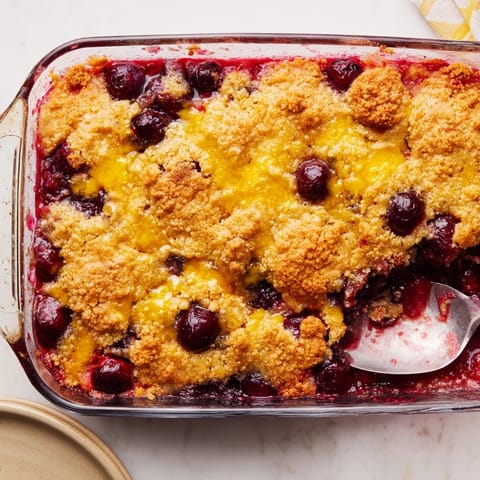 A freshly baked Dump Cake is served warm in a rustic bowl, perfect for a family dessert.