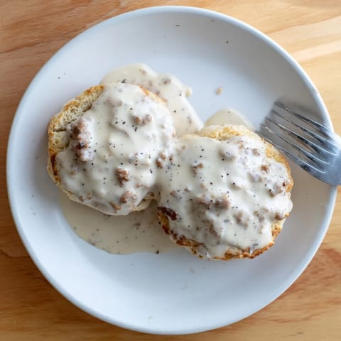 Flaky, golden biscuits smothered in creamy, peppery Biscuits and Gravy, served warm for a hearty Southern breakfast.
