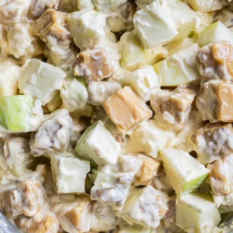 Snickers Salad dessert salad features crisp Granny Smith apples, vanilla pudding, whipped topping, and generous candy pieces.