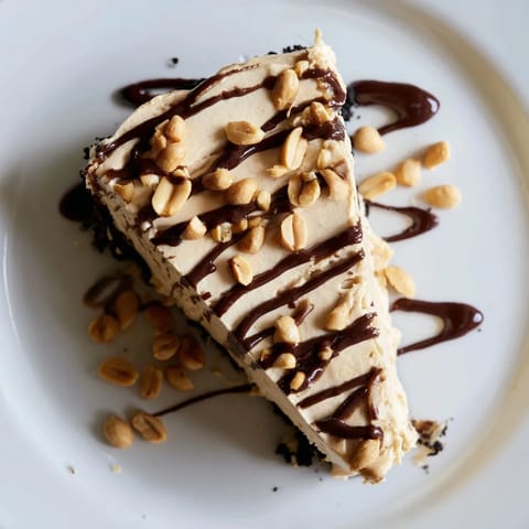 Rich slices of Peanut Butter Pie topped with a glossy chocolate ganache, served on a white dessert plate.