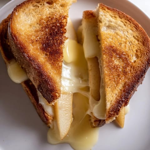 A close-up of a buttery grilled cheese featuring smoky Gouda and tart apple, melted.