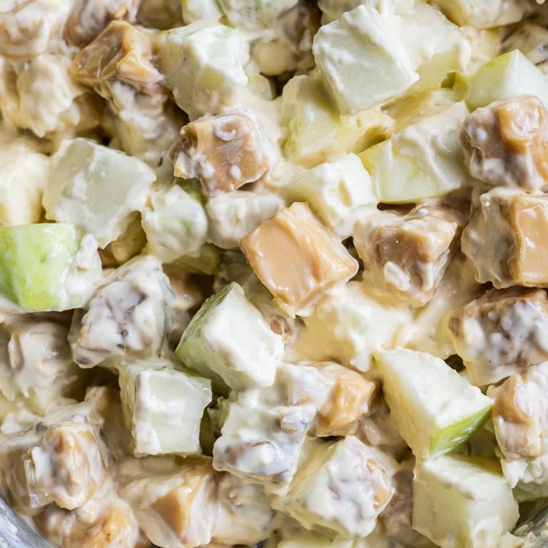 Snickers Salad dessert salad features crisp Granny Smith apples, vanilla pudding, whipped topping, and generous candy pieces.