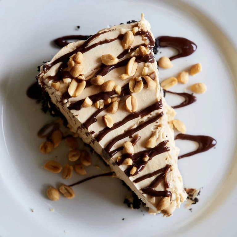 Rich slices of Peanut Butter Pie topped with a glossy chocolate ganache, served on a white dessert plate.