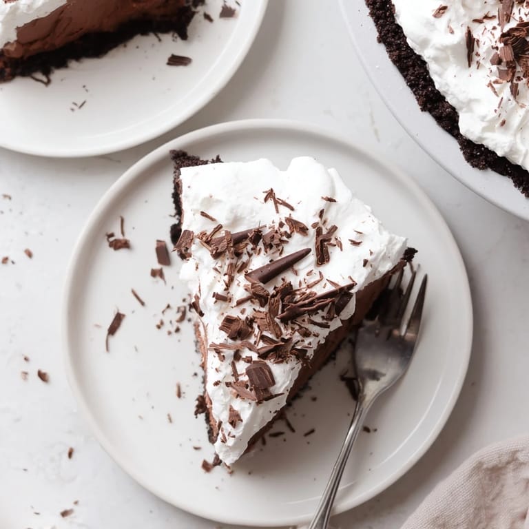Decadent Mississippi Mud Pie topped with whipped cream and chocolate curls, ready to serve with a glass of cold milk.