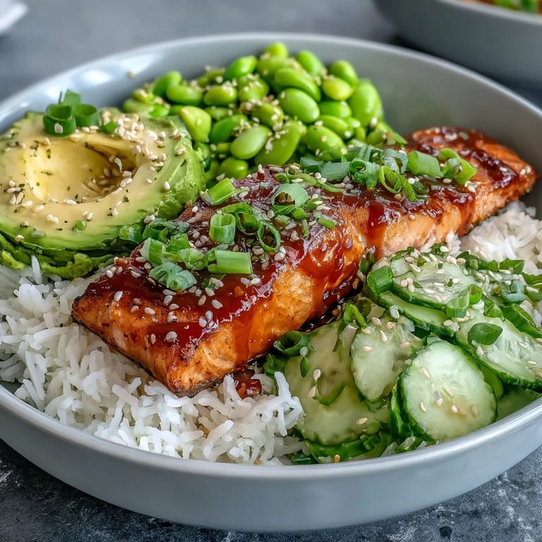 Close-up shot of a Honey Sriracha Salmon Bowl showing flaky glazed salmon, crisp veggies, and fluffy rice.